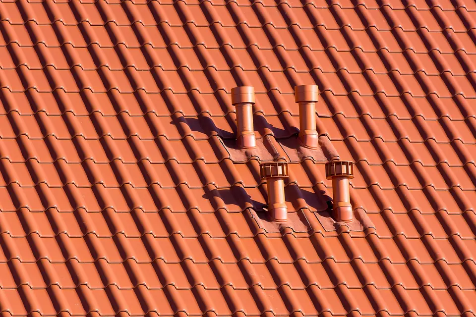 Conduits de ventilation sur une toiture en tuiles rouges